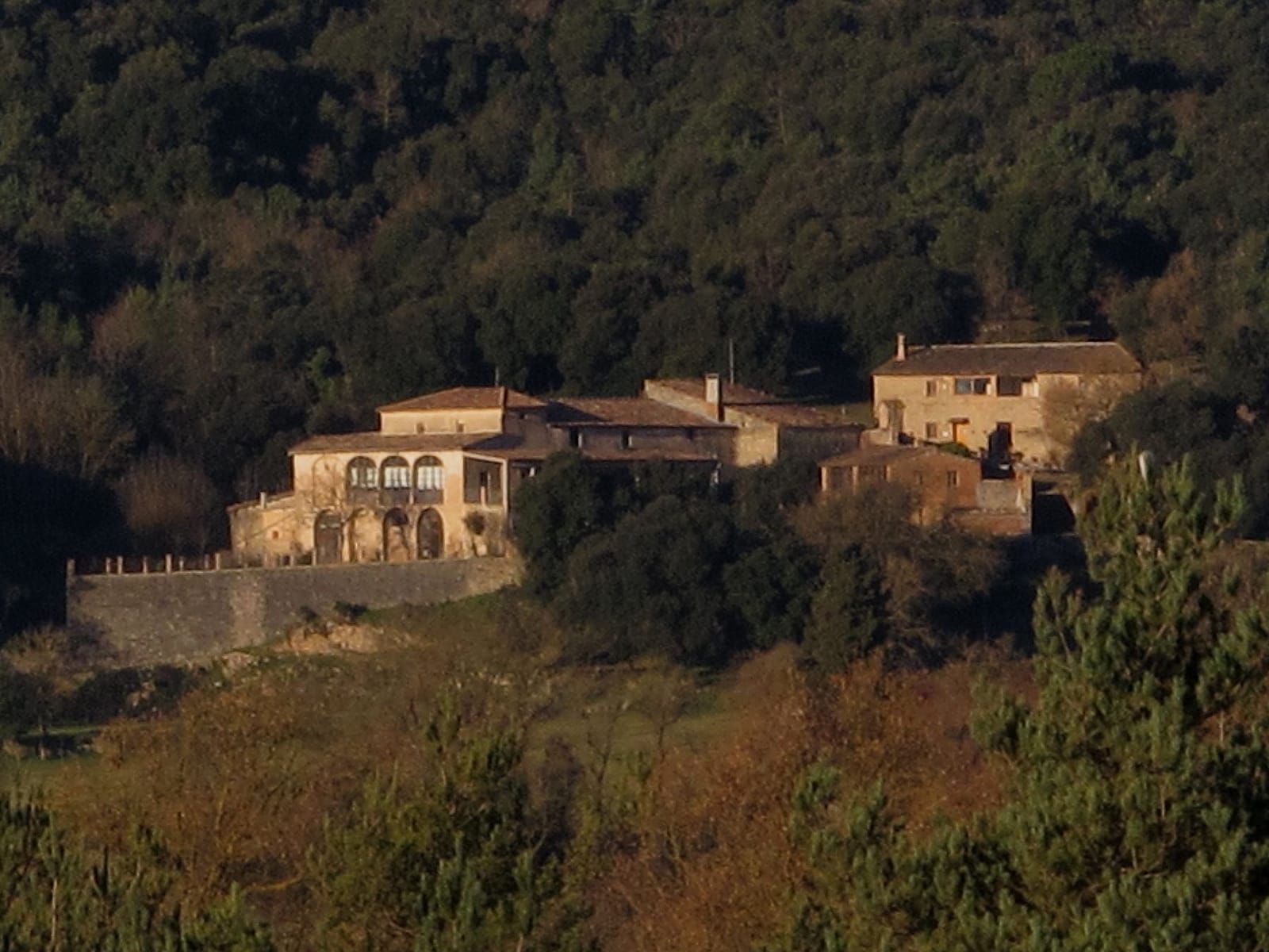 La masia de la Coma de Sant Jaume, amb la muralla i les galeries d'arcs